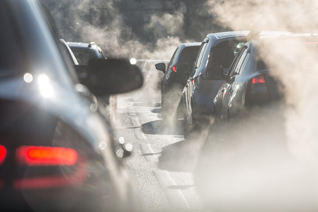 Cars in traffic jam emitting exhaust fumes